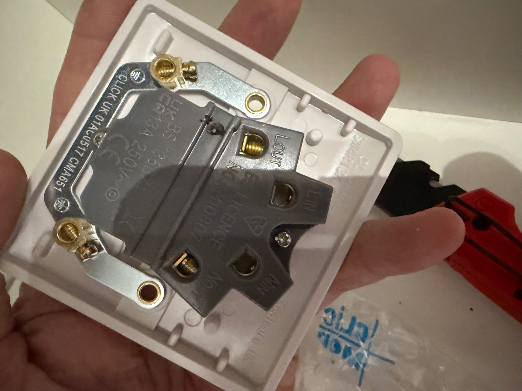 Rear of the new Click 13A 230V switched fused spur ready for termination — clean brass terminals and undamaged housing.
