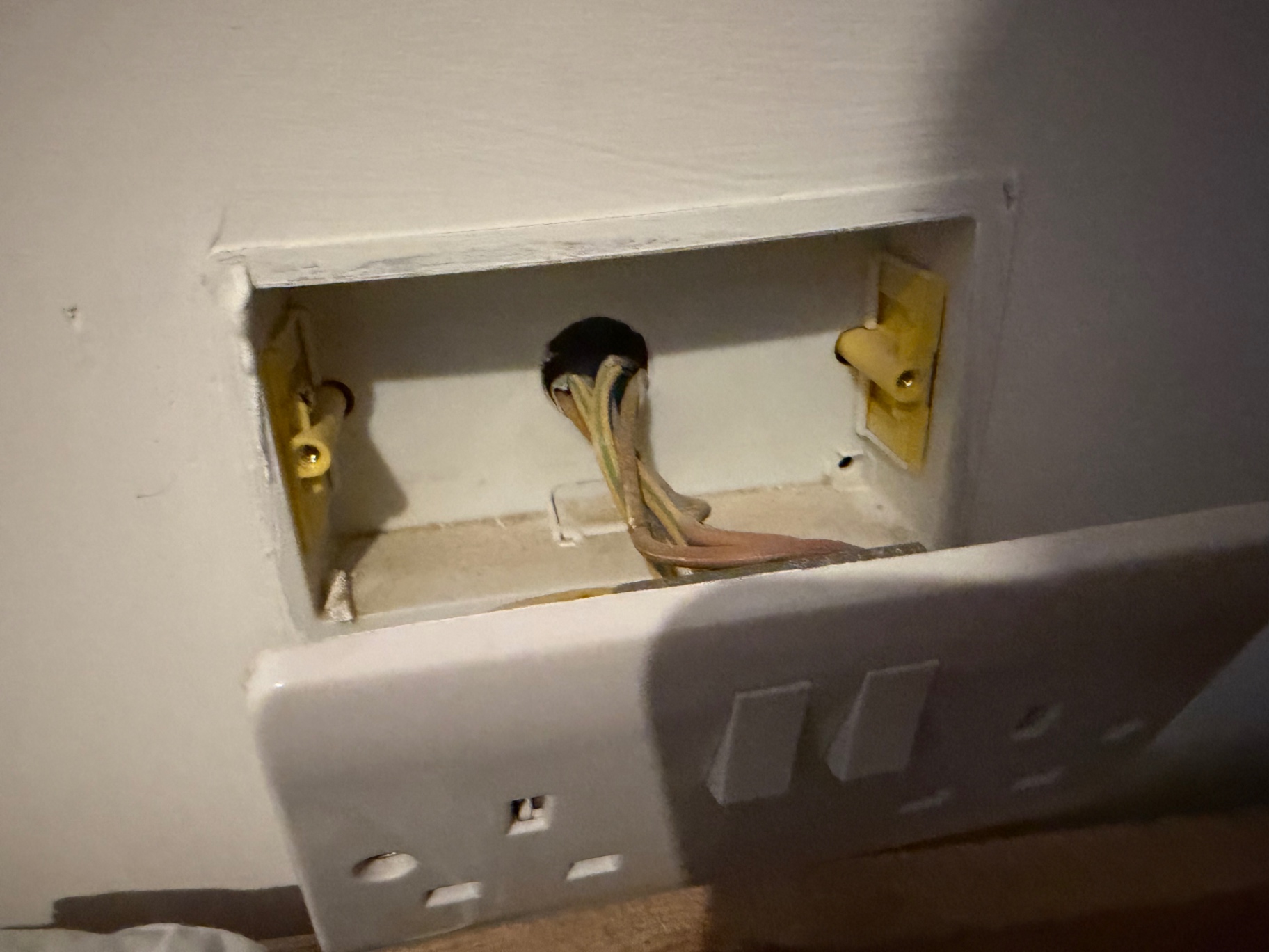 New 35mm back box fitted into the lath and plaster with earth-sleeved conductors dressed in