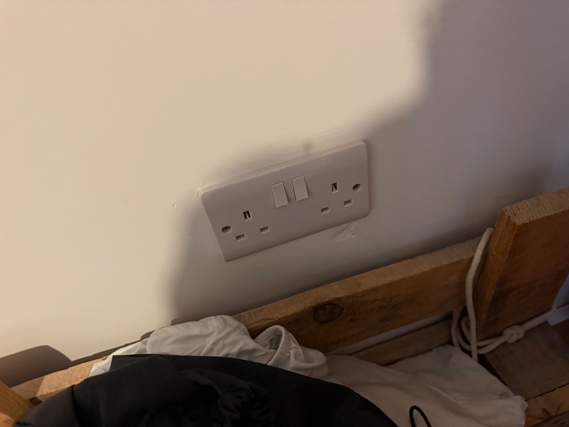 Existing single twin socket on the bedroom wall before works began
