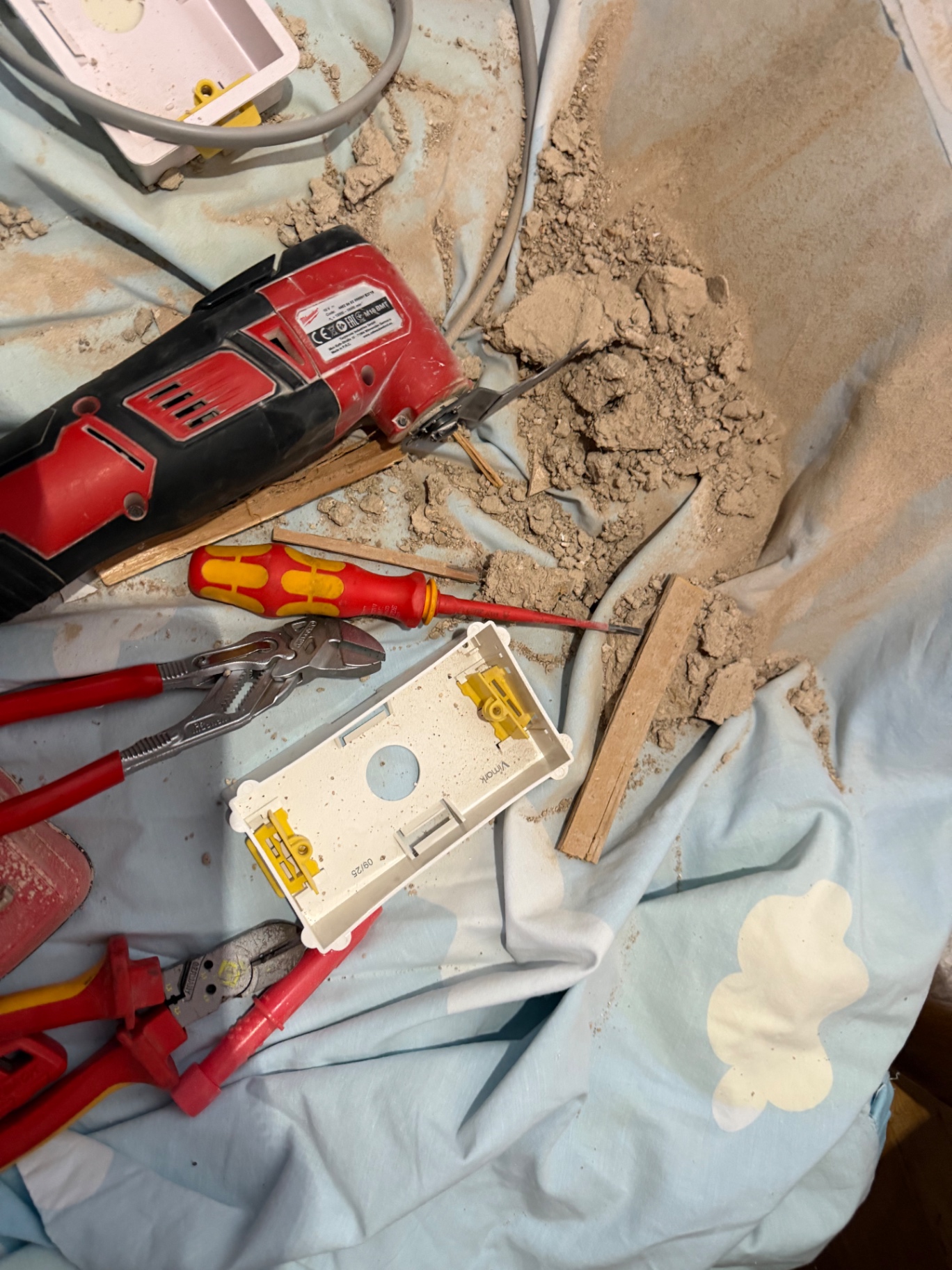 Milwaukee multi-tool, insulated screwdrivers and back box laid out on dust sheets — chasing lath and plaster