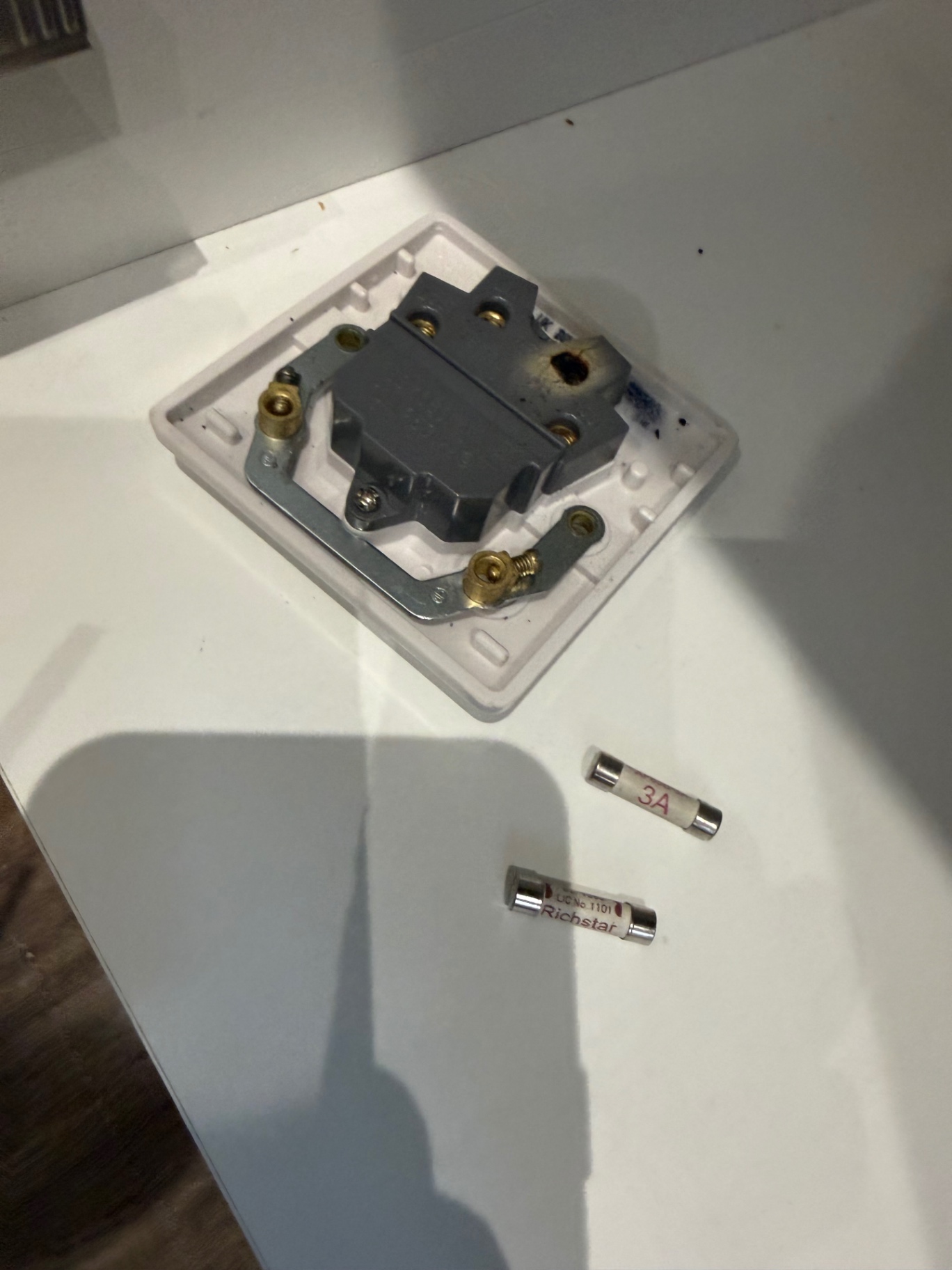 Faulty accessory removed from the wall, ready to be replaced with a new 13A switched fused spur.